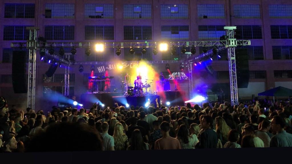 A daytime festival stage with a crowd