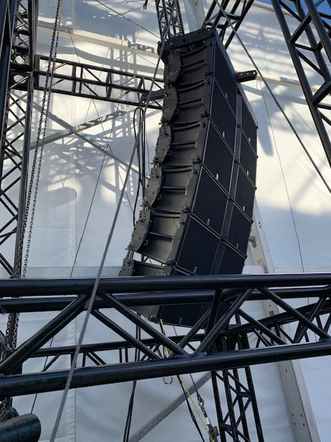 A line array flown against a clear sky