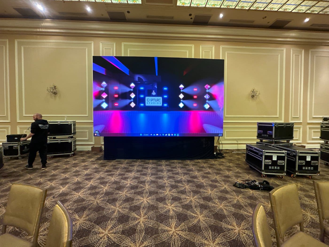 A stage lit in deep colour with an LED wall behind it
